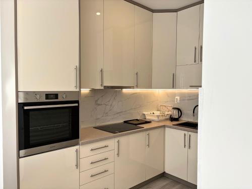a white kitchen with white cabinets and appliances at Villa Maja in Trebinje