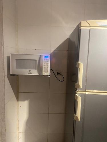 a microwave sitting on a wall in a kitchen at Espaço Nossa Casa, Piscina e churrasqueira Privativas in Paulista