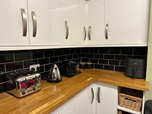 a kitchen with white cabinets and a toaster on a counter at Gorgeous Henrietta in Exmouth