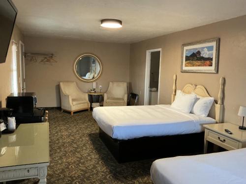 a hotel room with two beds and a table and chairs at Mexican Hat Lodge in Mexican Hat