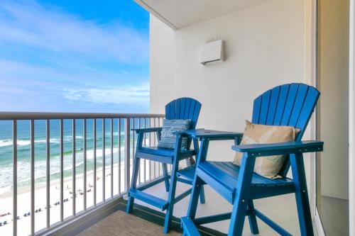 two blue chairs on a balcony with the beach at Beachfront Studio #909 at Majestic in Panama City Beach