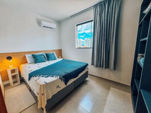 a small bedroom with a bed with a window at Apartamento de 1 quarto com sofá-cama no centro para até 4 pessoas in Brusque