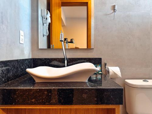 a bathroom with a sink in the middle of it at Apartamento de 1 quarto com sofá-cama no centro para até 4 pessoas in Brusque