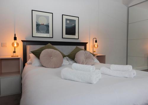 a white bed with pillows and towels on it at 38 Venn Park in Stoke Fleming