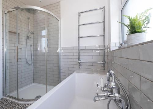 a white bathroom with a shower and a tub at 38 Venn Park in Stoke Fleming