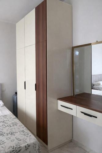 a bedroom with a bed and a dresser and a mirror at Arian North Coast Chalet Santorini Resort El Alamein in El Alamein