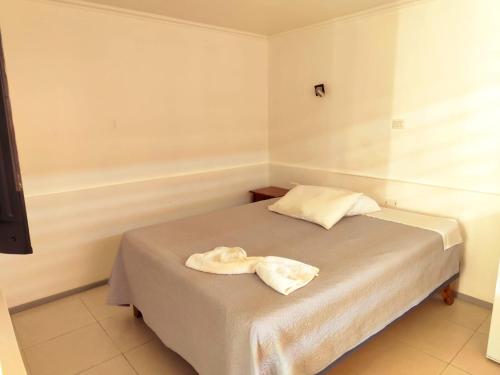 a bedroom with a bed with a towel on it at Hotel Marluz in Mejillones