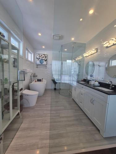 a bathroom with a tub and a toilet and a sink at Picturesque Luxury Waterside Villa in Niagara Falls