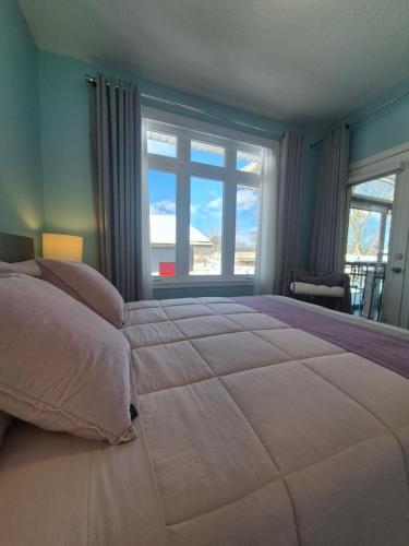 a bedroom with a large bed with a large window at Picturesque Luxury Waterside Villa in Niagara Falls