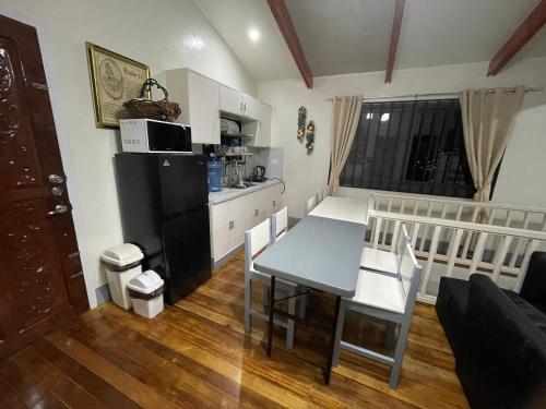 a kitchen and a dining room with a table and chairs at Rest Terraces Transient House in Baguio