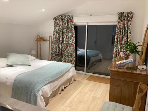 a bedroom with a bed and a mirror and a bedroom with a bed at Ty Moune in Crach