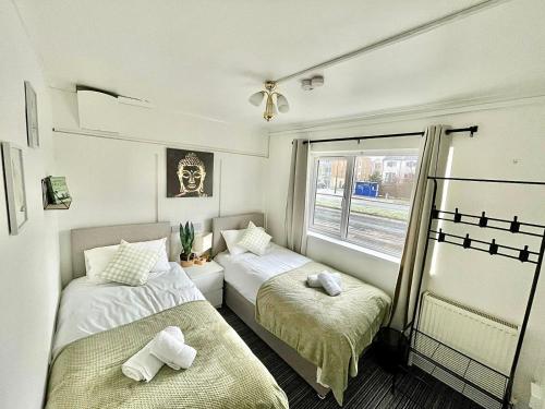 two beds in a small room with a window at Private 2Bed-Parking & Garden-By FabAccommodation in Bristol