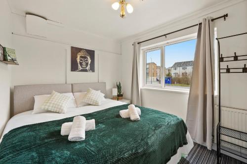 a bedroom with a large bed with towels on it at Private 2Bed-Parking & Garden-By FabAccommodation in Bristol