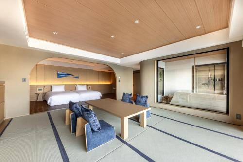 a bedroom with a bed and a table and chairs at IZU RETREAT ATAWAGA SUIKO by Onko Chishin in Higashiizu