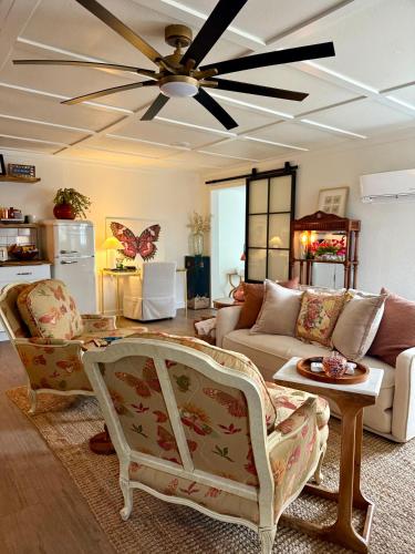 a living room with a couch and a ceiling fan at The Wing - luxurious king suite tiny studio home! in Eureka Springs