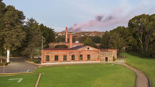 an old brick building with a grass field in front at Centro Vacacional Atlixco-Metepec in Atlixco
