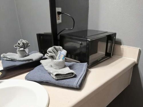 a microwave sitting on top of a counter with towels at King Bed Hotel Room 255 in Jackson