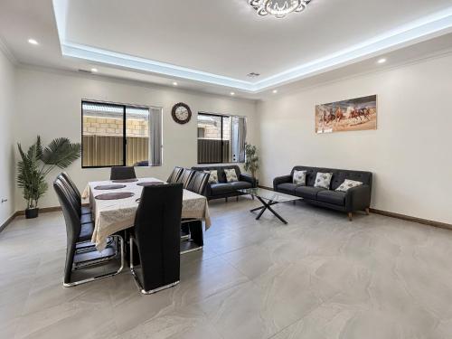 a living room with a table and chairs and a couch at Spacious 4 bed home with open plan living in Perth