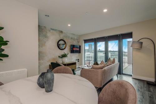 a bedroom with a bed and chairs and a living room at Luxury 2-Bed Apt by Royal Albert Dock & M&S Arena in Liverpool