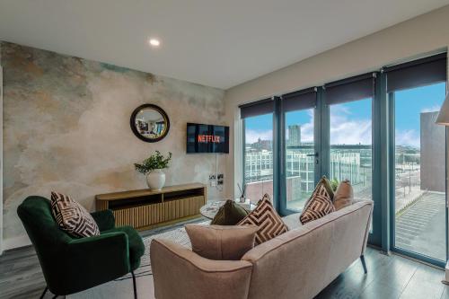 a living room with a couch and chairs and windows at Luxury 2-Bed Apt by Royal Albert Dock & M&S Arena in Liverpool