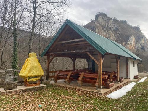 a gazebo with wooden benches and a yellow blob at Camp Budečevica in Žabljak