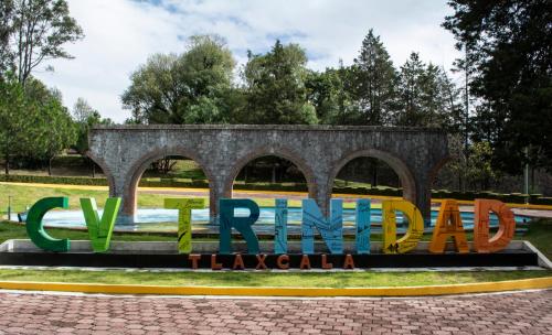 a sign in front of a park with a bridge at Centro Vacacional La Trinidad in Santa María Atlihuetzián