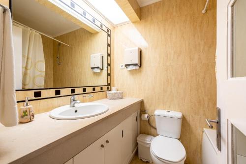 a bathroom with a sink and a toilet and a mirror at Simon's Place in Ponta Delgada