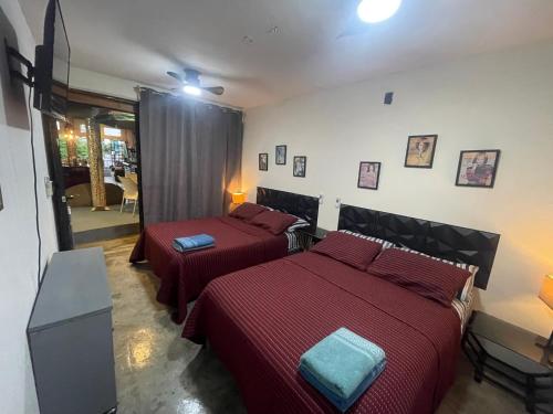 a bedroom with two beds with red sheets at Casa Maruja CoLiving Walk to Beach in Puerto Vallarta