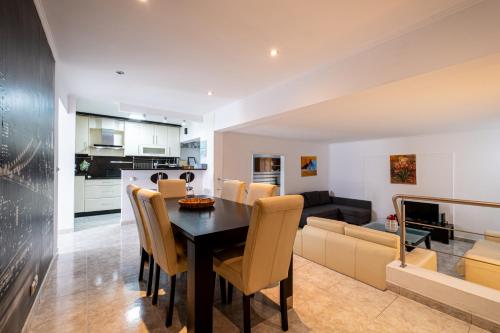 a dining room and living room with a table and a couch at Simon's Place in Ponta Delgada