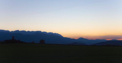 a sunset over a field with mountains in the background at Hotel Can Borrell in Meranges