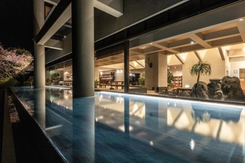 a swimming pool in a building at night at IZU RETREAT by Onko Chishin in Higashiizu
