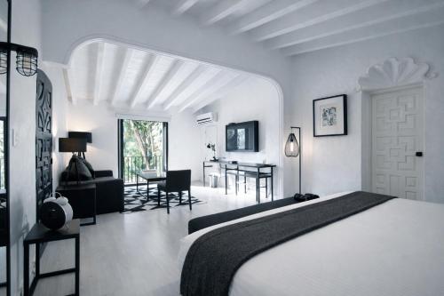 a white bedroom with a bed and a dining room at Las Casas B&B Boutique Hotel, Spa & Restaurante Cuernavaca in Cuernavaca