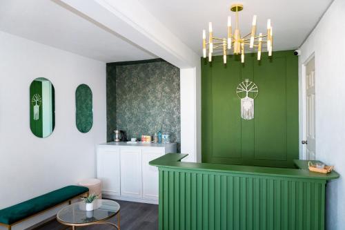 a room with a green wall with a chandelier at Hotel Embajada in San Luis Potosí