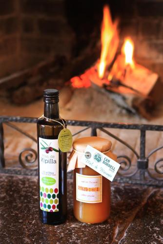 a bottle of sauce and a jar of honey in front of a fire at Hotel Can Borrell in Meranges