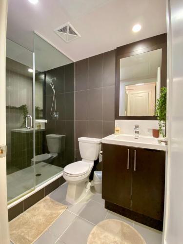 a bathroom with a toilet and a sink and a shower at Luxurious Condo Apartment with Direct Subway Access in Toronto