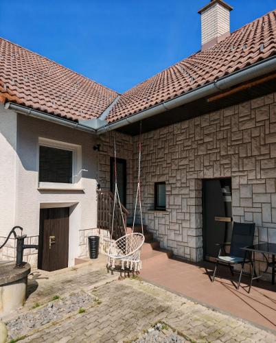 a house with a patio with chairs and a roof at Lusana in Moravske-Toplice