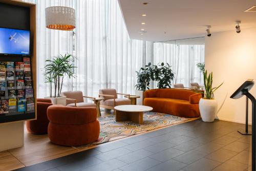 a lobby with couches and chairs and a table at Song Hotel Sydney in Sydney
