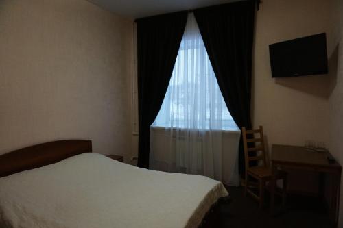 - une chambre avec un lit et une fenêtre avec un bureau dans l'établissement Yar Hotel, à Yaroslavl