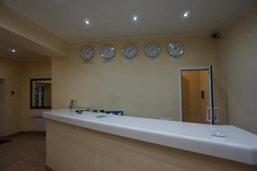 une salle d'attente avec des horloges sur le mur dans l'établissement Yar Hotel, à Yaroslavl