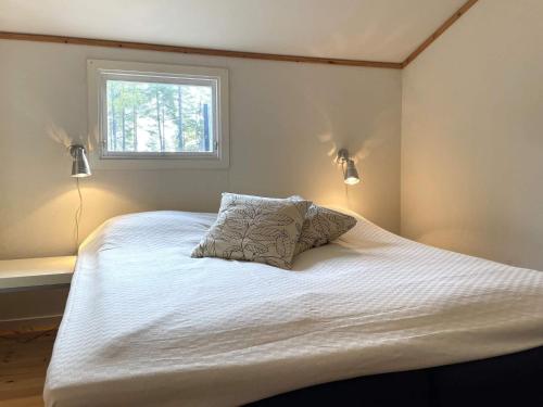 a bedroom with a white bed with a window at 4 person holiday home in VALDERMARSVIK in Valdemarsvik