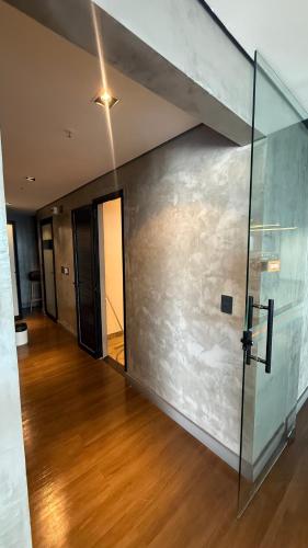 a room with a glass wall and a wooden floor at Flat particular no Hotel Intercity Manaus in Manaus