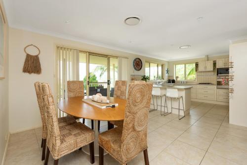 a kitchen and dining room with a wooden table and chairs at You, Me & The Sea - Walk to Mollymook Beach in Mollymook