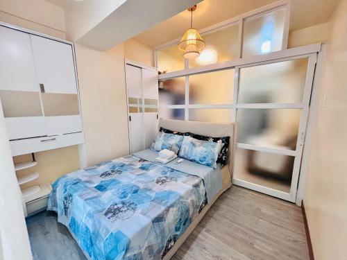 a small bedroom with a bed and a window at RR 21 Milan Residenze Fairview in Manila