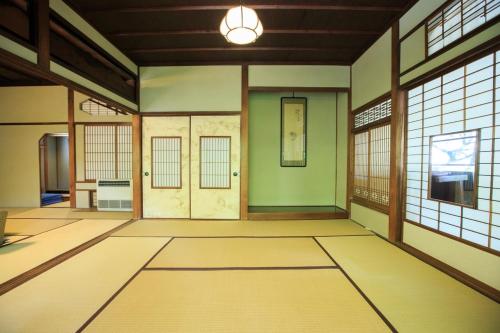 an empty room with green walls and windows at Fukuzumiro in Hakone