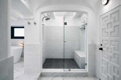 a white bathroom with a shower and a glass door at Las Casas B&B Boutique Hotel, Spa & Restaurante Cuernavaca in Cuernavaca