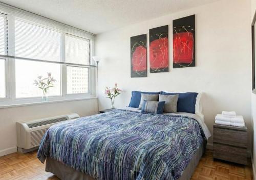 a bedroom with a bed and two windows at Skyline with Hudson Views Modern Battery Park Stay in New York