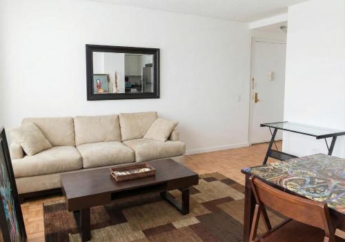 a living room with a couch and a table at Skyline with Hudson Views Modern Battery Park Stay in New York