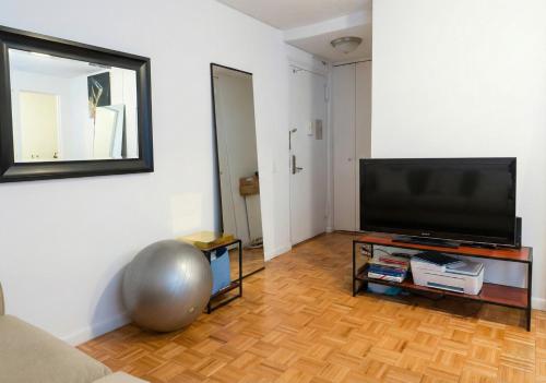a living room with a large flat screen tv at Skyline with Hudson Views Modern Battery Park Stay in New York