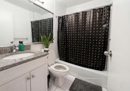 a bathroom with a toilet and a shower curtain at Skyline with Hudson Views Modern Battery Park Stay in New York