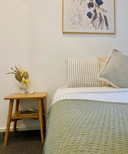 a bedroom with a bed and a table with a vase of flowers at Sea Haven, A Rye Coastal Retreat! in Rye